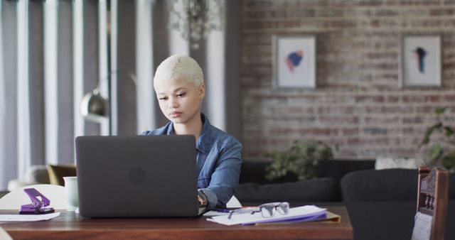 Young woman working from home using laptop at modern loft apartment - Download Free Stock Images Pikwizard.com