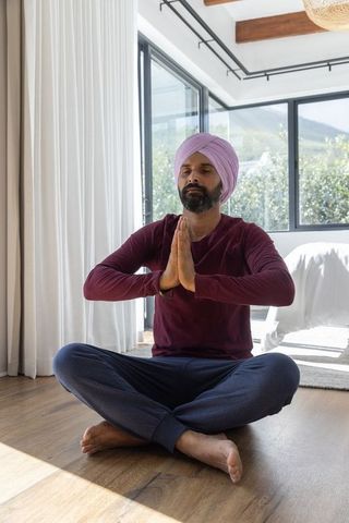 Indian Man Meditating on Floor Enjoying Relaxing Home Environment
