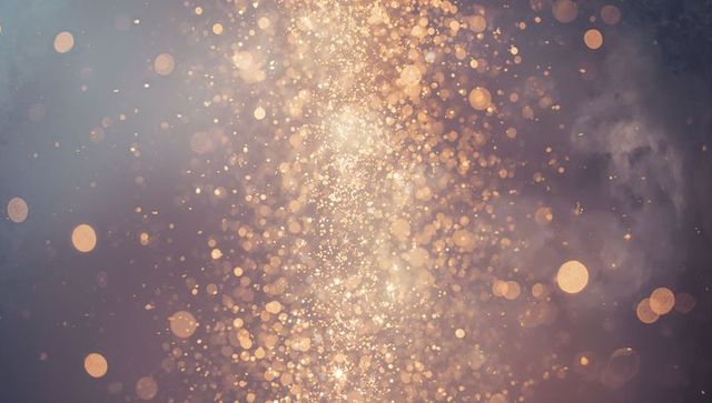 Golden vertical light column with sparkling bokeh particles and ethereal glitter shimmer