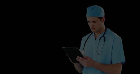 Surgeon in Scrubs Studying Tablet Technology Holding Stethoscope