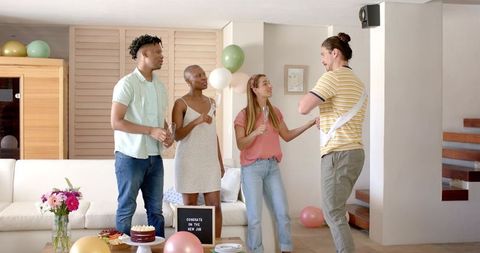 Friends Toasting New Job Celebration at Home with Cake, Balloons and Sashed Honoree