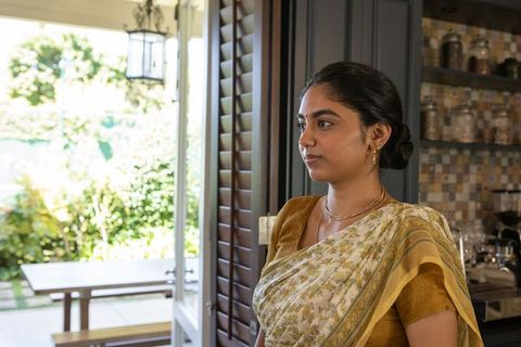 Indian Woman in Stylish Sari Standing by Sunlit Garden