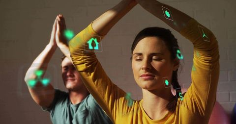 Couple practicing partner yoga and meditation with augmented reality wellness icons