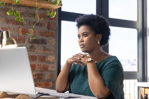 Focused Businesswoman Deep in Thought at Modern Office Workspace