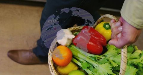 Midadult Man Carrying Woven Basket of Fresh Peppers, Celery and Citrus Produce