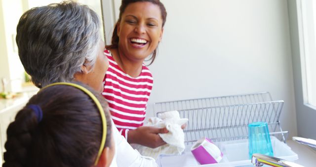 Multigenerational Family Laughing and Cleaning Kitchen Dishes Together - Download Free Stock Images Pikwizard.com