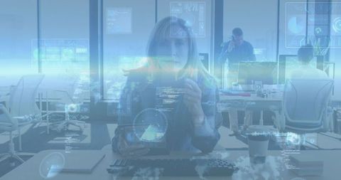 Mature businesswoman holding tablet in open-plan office with holographic dashboards, code
