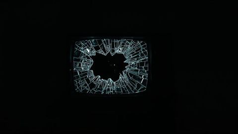 Vintage crt television with shattered screen in dark room