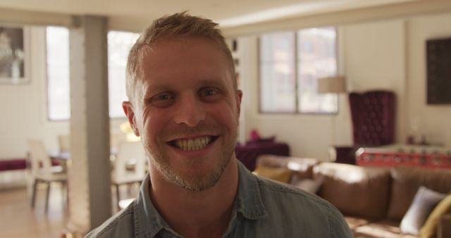 Smiling man with casual outfit in modern living room with natural light - Download Free Stock Images Pikwizard.com