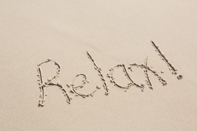 Handwritten 'Relax' on sandy beach conveys a message of tranquility and leisure. Ideal for travel brochures, vacation advertisements, relaxation-themed content, and social media posts promoting calm and peaceful vibes.
