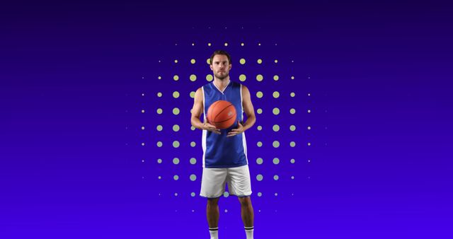 Male basketball player wearing blue uniform holding basketball against blue background with dotted pattern. Ideal for sports advertisements, athlete promotion, basketball events, and fitness posters.