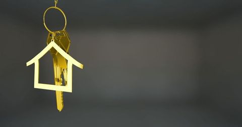 Golden house keychain symbolizing real estate investment