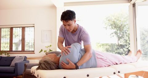 Male Physiotherapist Assisting Senior Woman in Rehabilitation Session