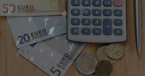 Counting euros with calculator and coins on wooden desk for budget planning
