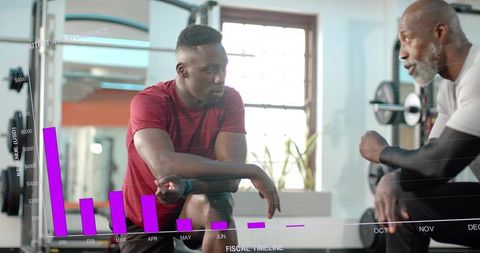 Personal trainer coaching male client in gym with purple performance graph overlay