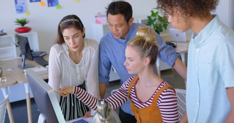 Colleagues collaborating on project at modern office desk