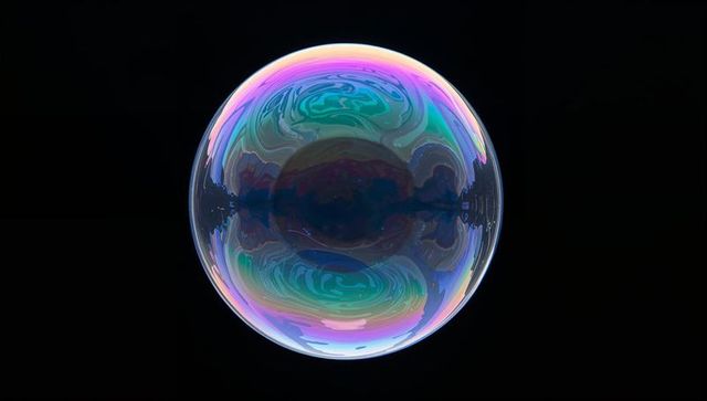 Vibrant iridescent soap bubble on black