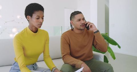 Diverse Couple Reviewing Documents in Modern Living Room
