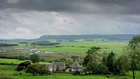 Idyllic Countryside Landscape with Farmhouses and Rolling Hills