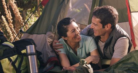 Happy couple camping adventure smiling inside cozy tent