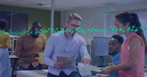 Team Leader Pointing at Document While Collaborating with Team in Open-Plan Office