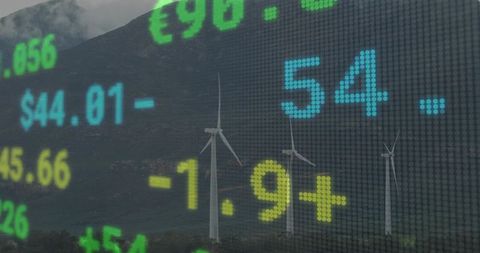 Wind Turbines with Financial Ticker Overlay Reflecting Green Energy Economics