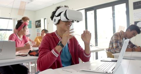 Teen Using Virtual Reality Headset in Classroom for Interactive Learning and Collaboration