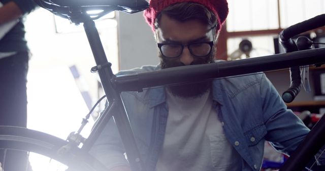 Young Man Adjusting Bicycle in Workshop - Download Free Stock Images Pikwizard.com