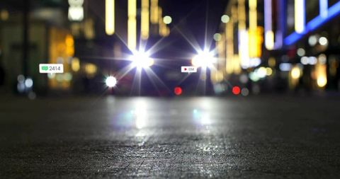 Glowing Night Street Scene with Futuristic Vehicle Headlights
