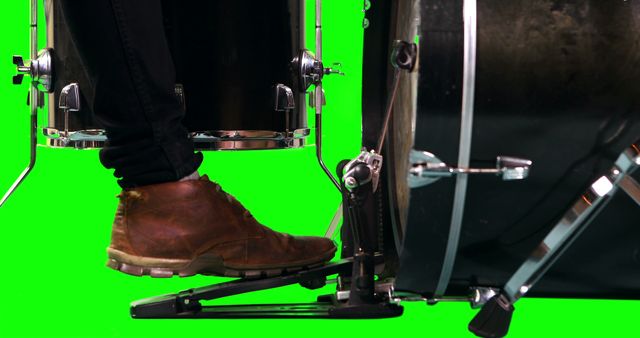 Man's foot pressing bass drum pedal while playing drums on green screen background. Perfect for music tutorials, promotions for drumming equipment, or compositions involving isolated objects for creative digital projects.