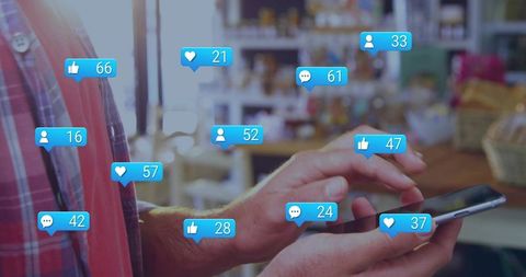 Tapping smartphone showing social media notification badges at cafe counter