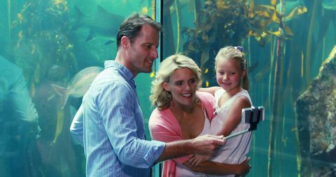 Family Capturing Selfie at Aquarium with Underwater Scene
