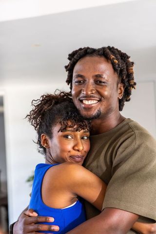 African american couple hugging at home showing warmth, affection and joyful connection
