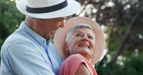 Joyful Senior Couple Embracing Outdoors with Smiling Faces