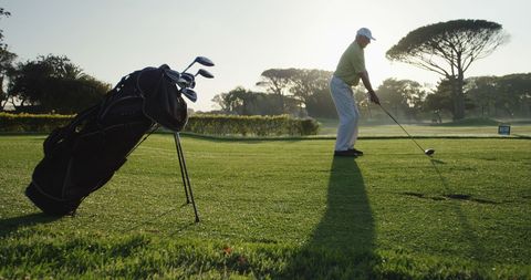 Golfer Practicing Swing on Scenic Green with Golf Bag