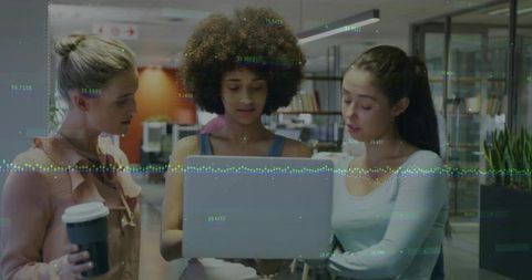 Three Women Collaborating Over Laptop with Data Overlay in Modern Open Office Space