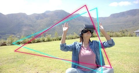 Teen in denim jacket wearing vr headset and headphones interacting with neon triangles