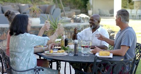 Diverse friends toasting at outdoor patio dining table