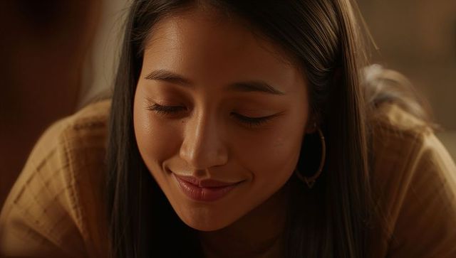 Warm closeup portrait smiling woman closing eyes tilting head tan knit gold hoop earrings