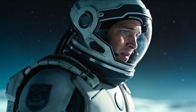 Solitary astronaut scanning icy horizon through fogged visor with mission patch
