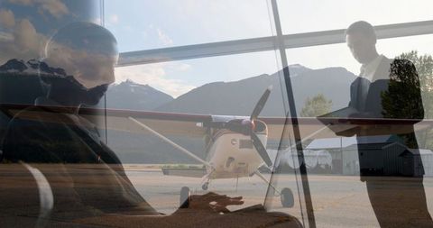 Colleagues Working with Airplane Outside Business Lounge