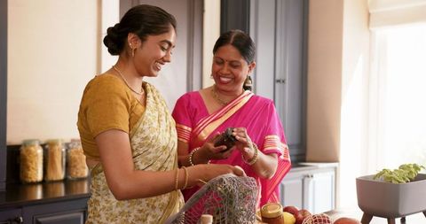 Indian Mother and Daughter Cooking Together in Traditional Attire