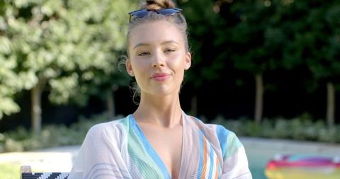 Elegant woman relaxing by pool in summer attire