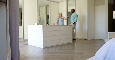 Romantic Couple Engaging with Jewelry in Modern Bedroom Space