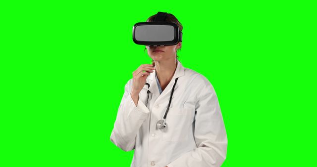 Female doctor using virtual reality headset, standing against a green screen background. Ideal for presentations about virtual reality in healthcare, telemedicine, modern technology in medicine, and educational training materials.