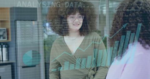 Businesswoman analyzing financial data in modern office featuring diverse team