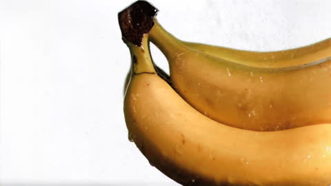 Refreshing Ripe Bananas under Slow Motion Water Stream