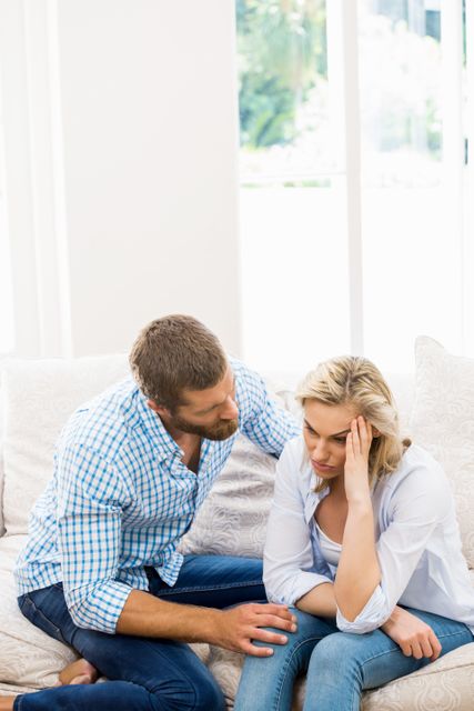 Man comforting her woman in living room at home