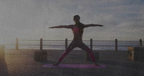 Woman Practicing Warrior II Yoga at Sunrise on Seafront Promenade