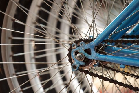 Close-up of bicycle wheel highlighting metal spokes and chain